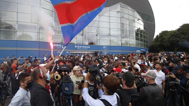 Fans PSG berkumpul dan bersorak di Parc des Princes menyambut kedatangan pemain anyar klub papan atas Liga Prancis itu, Lionel Messi, Selasa (10/8/2021).  [AFP Photo]