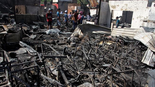 Sejumlah warga melihat puing rumah yang hangus terbakar di salah satu permukiman padat penduduk di Kecamatan Tamalate, Makassar, Sulawesi Selatan, Rabu (11/8/2021).  ANTARA FOTO/Arnas Padda
