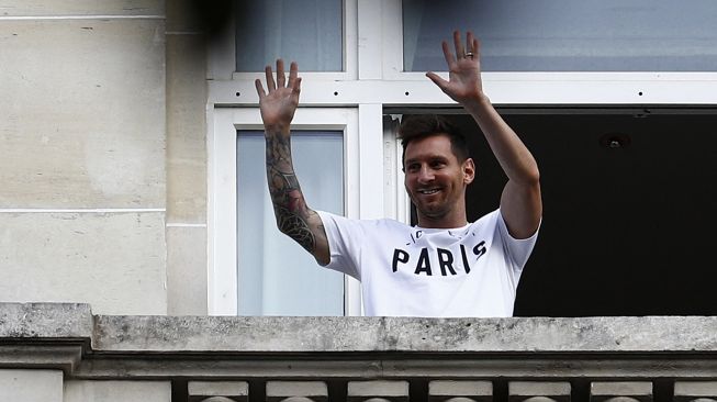 Pesepak bola Lionel Messi menyapa penggemarnya dari balkon hotel Royal Monceau, Paris, Prancis, Selasa (10/8/2021).  [AFP Photo]