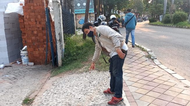 Warga sekitar menunjukan lokasi video ditemukannya potongan tangan di atas motor di sekitar Plaza Shinta Tangerang. [Suara.com Muhammad Jehan Nurhakim]