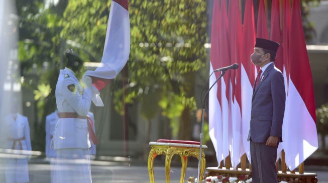 Presiden Joko Widodo (kanan) memimpin Upacara Pengukuhan anggota Pasukan Pengibar Bendera Pusaka (Paskibraka) di halaman Istana Merdeka, Jakarta, Kamis (12/8/2021). [ANTARA FOTO/Biro Pers Media Setpres/Muchlis Jr]