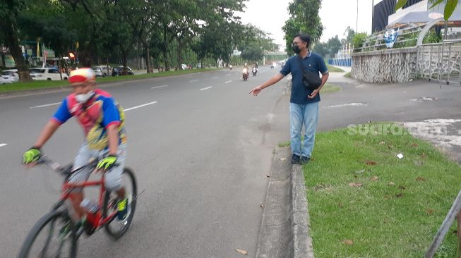 Salah seorang warga menunjuk lokasi artis Virnie Ismail kecelakaan saat bersepeda di Jalan Boulevard Bintaro, Pondok Aren, Kota Tangsel, Kamis (12/8/2021). [SuaraJakarta.id/Wivy Hikmatullah]