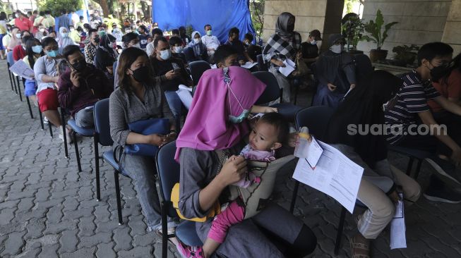 Sejumlah warga mengantre untuk mendapatkan vaksinasi COVID-19 di Gedung Wira Purusa LVRI DKI Jakarta, Kamis (12/8/2021). [Suara.com/Angga Budhiyanto]