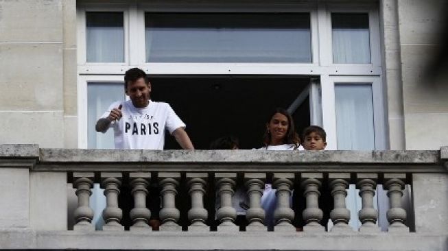 Lionel Messi bersama istri dan puteranya di balkon Hotel Le Royal Monceau, Paris, Selasa (10/8/2021). [AFP]