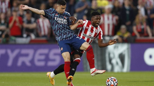 Striker Arsenal Gabriel Martinelli (kiri) berebut bola dengan gelandang Brentford  Frank Onyeka (kanan) selama pertandingan sepak bola Liga Premier Inggris antara Brentford dan Arsenal di Brentford Community Stadium, London, pada (13/8/2021). [Adrian DENNIS / AFP]