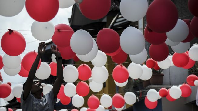 Warga memasang hiasan balon merah putih di Gang Pasir Reuma, Coblong, Bandung, Jawa Barat, Sabtu (14/8/2021). [ANTARA FOTO/Raisan Al Farisi]