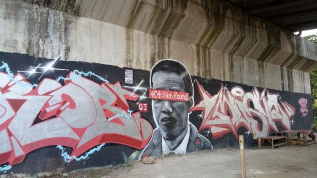 Mural 'Jokowi 404:Not Found' berada di bawah jembatan layang Jalan Pembangunan 1, Kelurahan Batujaya, Kecamatan Batuceper, Kota Tangerang. Kekinian mural mirip Presiden Joko Widodo (Jokowi) itu telah dihapus. [Ist]