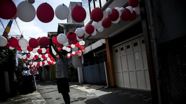 Warga memasang hiasan balon merah putih di Gang Pasir Reuma, Coblong, Bandung, Jawa Barat, Sabtu (14/8/2021). [ANTARA FOTO/Raisan Al Farisi]