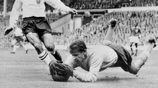 Aksi kiper legendaris Uni Soviet, Lev Yashin, saat melawan pemain Inggris Jimmy Greaves pada 1963. (STAFF / AFP)