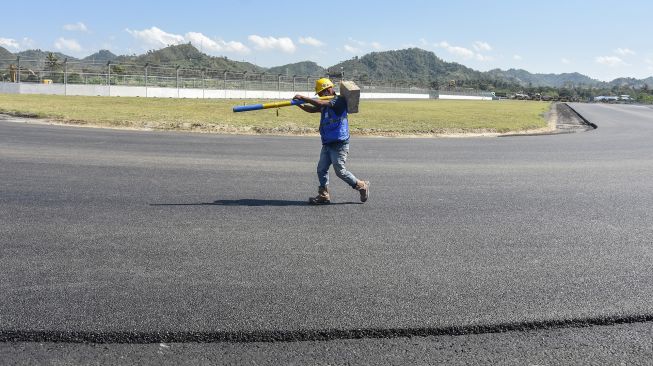 Seorang pekerja berada di tikungan ke 2 lintasan Mandalika International Street Circuit di Kawasan Ekonomi Khusus (KEK) Mandalika, Pujut, Praya, Lombok Tengah, NTB, Minggu (15/8/2021). ANTARA FOTO/Ahmad Subaidi