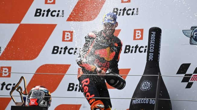 Rider KTM, Brad Binder melakukan selebrasi usai memenangi MotoGP Austria yang digelar di Sirkuit Red Bull Ring, Spielberg, Austria, Minggu (15/8/2021) malam WIB. [Joe Klamar / AFP]