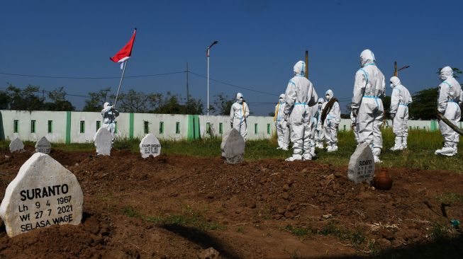 Sejumlah relawan pemakaman jenazah protokol COVID-19 dengan mengenakan Alat Pelindung Diri (APD) melakukan upacara bendera dalam rangka peringatan Hari Ulang Tahun ke-76 Proklamasi Kemerdekaan RI di Pemakaman Pagu Indah Kota Madiun, Jawa Timur, Minggu (15/8/2021).  ANTARA FOTO/Siswowidodo