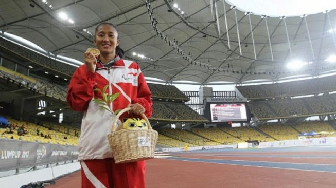 Pelari difabel Indonesia, Putri Aulia, berpose selepas menyabet medali emas ASEAN Para Games 2017 nomor 400 meter T13 putri di Kuala Lumpur, Malaysia, Selasa (19/9/2017). (ANTARA News/Istimewa)