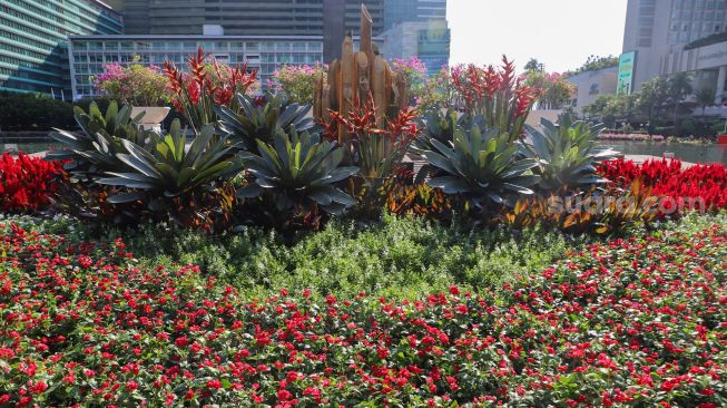 Dekorasi bunga bernuansa merah putih terpajang di kawasan Bundara Hotel Indonesia (HI), Jakarta Pusat, Senin (16/8/2021). [Suara.com/Alfian Winanto]