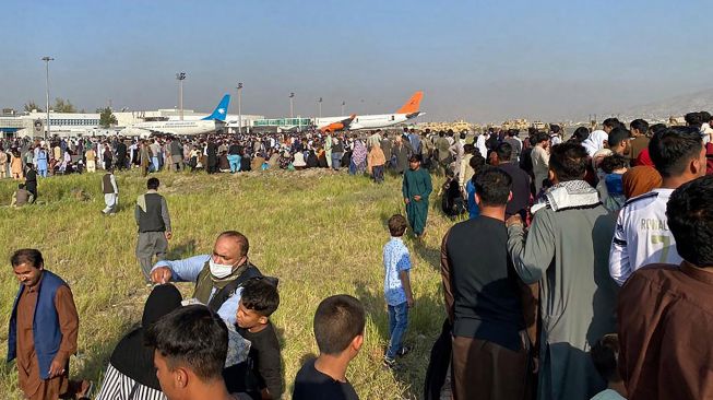 Warga berkumpul Bandara Internasional Hamid Karzai di Kabul, Afghanistan, Senin (16/8/2021).  [AFP Photo]