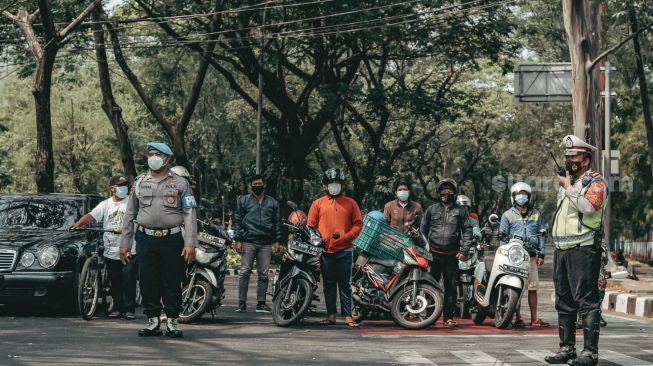 Sejumlah aparat keamanan tengah bersiap untuk memperingati hari  kemerdekaan Indonesia di Tugu TMP Kota Tangerang, Selasa 17 Agustus 2021. [Suara.com/ Hilal Rauda Fiqry]