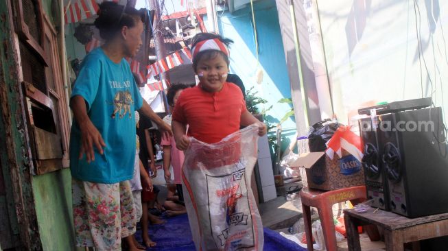 Anak-anak mengikuti lomba balap karung di Menteng, Jakarta, Selasa (17/8).  [Suara.com/Oke Atmaja]
