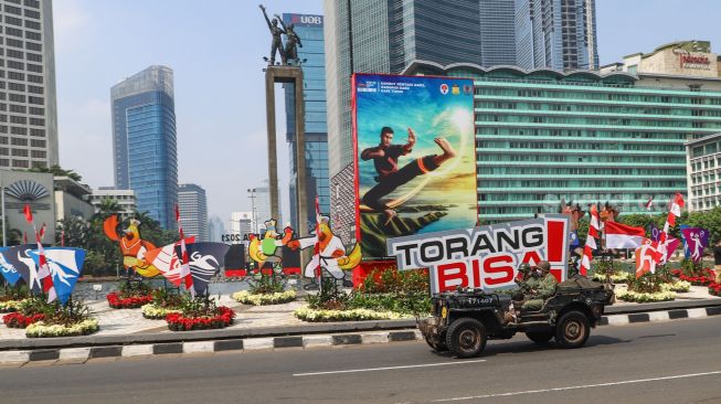 Komunitas Mobil Klasik melintas di kawasan Bundaran Hotel Indonesia (HI), Jakarta Pusat, Selasa (17/8/2021). [Suara.com/Alfian Winanto]