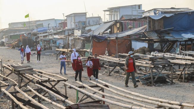 Anak-anak dari Komunitas Kelas Jurnalis Cilik usai melakukan upacara bendera HUT RI ke-76 di Belah Kapal, Cilincing, Jakarta Utara, Selasa (17/8/2021). [Suara.com/Alfian Winanto]