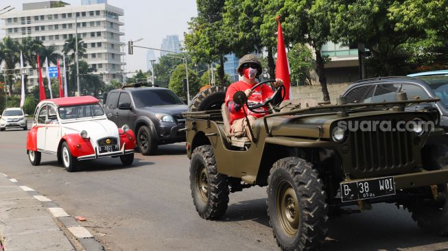 Komunitas Mobil Klasik melintas di kawasan Bundaran Hotel Indonesia (HI), Jakarta Pusat, Selasa (17/8/2021). [Suara.com/Alfian Winanto]