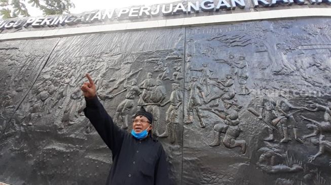Sejarawan Kota Tangerang Selatan TB Sos Rendra berada di monumen dan relief Pahlawan Seribu di Cilenggang, Serpong, Tangsel, Senin (16/8/2021). [SuaraJakarta.id/Wivy Hikmatullah]