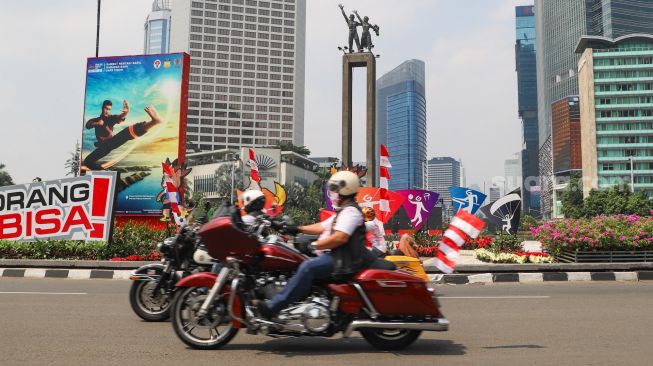 Komunitas Motor Gede (Moge) melintas sambil mengibarkan bendera merah putih di kawasan Bundaran Hotel Indonesia (HI), Jakarta Pusat, Selasa (17/8/2021). [Suara.com/Alfian Winanto]