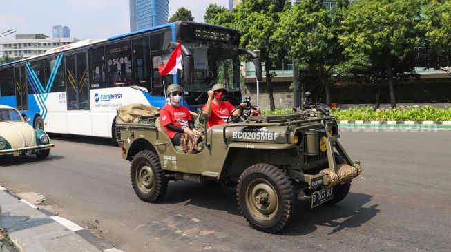 Komunitas Mobil Klasik melintas di kawasan Bundaran Hotel Indonesia (HI), Jakarta Pusat, Selasa (17/8/2021). [Suara.com/Alfian Winanto]