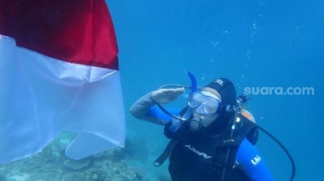 Pengibaran bendera Merah Putih di bawah laut Pulau Kodingareng Kota Makassar oleh penyelam Unhas [SuaraSulsel.id / Unhas]