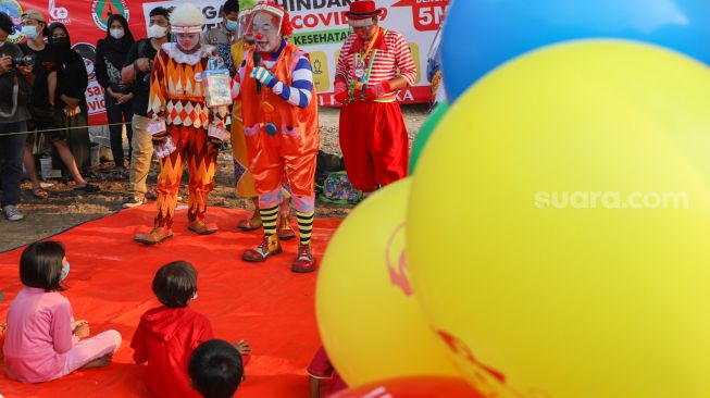 Sejumlah Badut yang tergabung dalam komunitas Aku Badut Indonesia (ABI) menghibur anak-anak di pengungsian korban kebakaran di Jl. Kemang Utara IX, Jakarta Selatan, Rabu (18/8/2021). [Suara.com/Alfian Winanto]