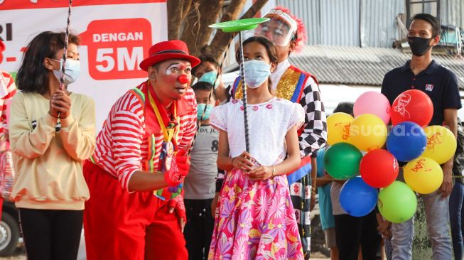 Sejumlah Badut yang tergabung dalam komunitas Aku Badut Indonesia (ABI) mengajak bermain anak-anak di pengungsian korban kebakaran di Jl. Kemang Utara IX, Jakarta Selatan, Rabu (18/8/2021). [Suara.com/Alfian Winanto]