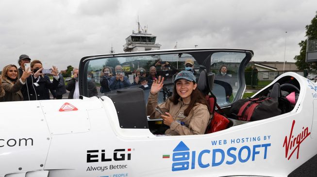 Pilot Zara Rutherford duduk di kokpit pesawat sebelum lepas landas di lapangan terbang Kortrijk-Wevelgem, Belgia, Rabu (18/8). [Foto/AFP]