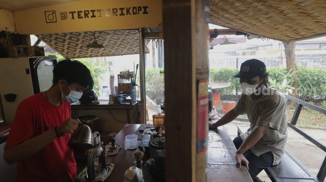 Barista melayani pembeli kopi di salah satu pusat jajanan di kawasan Jagakarsa, Jakarta, Kamis (19/8/2021). [Suara.com/Angga Budhiyanto]