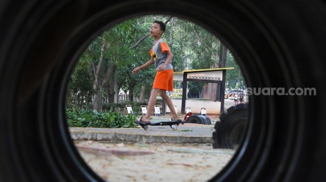 Anak-anak berolahraga sore di Jalur Banjir Kanal Timur, Jakarta Timur, Kamis (19/8/2021). [Suara.com/Alfian Winanto]