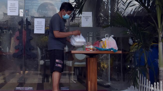 Pasien COVID-19 mengambil makanan pada area tempat isolasi terpusat di Badung, Bali, Jumat (20/8/2021). ANTARA FOTO/Nyoman Hendra Wibowo