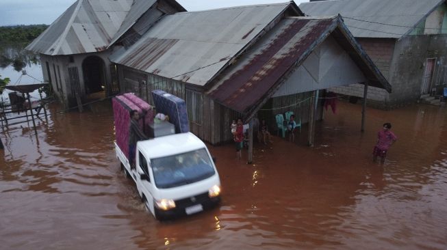 Warga menyelamatkan barang dari banjir di Desa Wanoamonapa, Kecamatan Pondidaha, Konawe, Sulawesi Tenggara, Sabtu (21/8/2021). [ANTARA FOTO/Jojon]