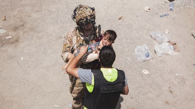 Marinir AS yang ditugaskan di Unit Ekspedisi Kelautan (MEU) ke-24 menggendong bayi saat evakuasi di Bandara Internasional Hamid Karzai, Kabul, Afghanistan, dalam foto yang diambil Jumat (20/8/2021). [AFP Photo]