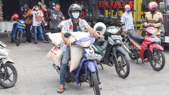 Pembeli membeli beras di Pasar Induk Beras, Cipinang, Jakarta Timur, Sabtu (21/8/2021). [Suara.com/Alfian Winanto]