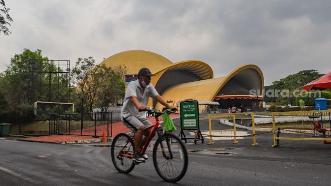 Warga berolahraga sore di kawasan Taman Mini Indonesia Indah, Jakarta Timur, Sabtu (21/8/2021). [Suara.com/Alfian Winanto]