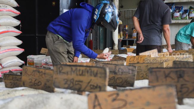 Calon pembeli memilih beras di Pasar Induk Beras, Cipinang, Jakarta Timur, Sabtu (21/8/2021). [Suara.com/Alfian Winanto]