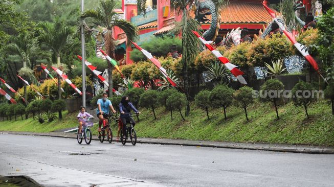 Warga bersepeda di kawasan Taman Mini Indonesia Indah, Jakarta Timur, Sabtu (21/8/2021). [Suara.com/Alfian Winanto]