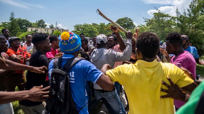 Pendukung mantan Presiden Haiti Michel Martelly adu jotos dengan pengawal Martelly di depan rumah sakit OFATMA setelah Martelly pergi, di Les Cayes, Haiti, Jumat (20/8/2021).  [ANTARA FOTO/REUTERS]