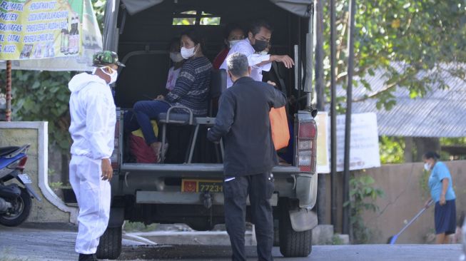 Prajurit TNI menjemput warga yang terkonfirmasi positif COVID-19 menuju lokasi isolasi terpusat (isoter) di kawasan Kuta Selatan, Badung, Bali, Sabtu (21/8/2021). [ANTARA FOTO/Fikri Yusuf]