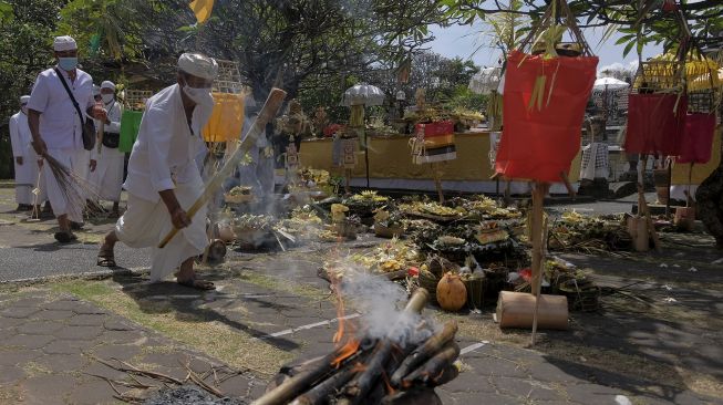 Umat Hindu melakukan ritual persembahyangan saat Upacara "Wisuda Bumi" pada Pemberlakuan Pembatasan Kegiatan Masyarakat (PPKM) Level 4 di Pura Agung Jagatnatha, Denpasar, Bali, Minggu (22/8/2021). [ANTARA FOTO/Nyoman Hendra Wibowo]