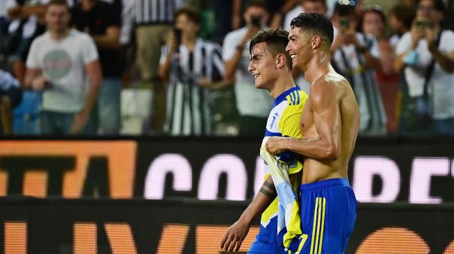 Pemain depan Juventus Cristiano Ronaldo (kanan) berjalan dengan pemain depan Juventus Paulo Dybala selama pertandingan sepak bola Serie A Italia antara Udinese melawan Juventus di Stadion Friuli, Senin (23/8) dini hari WIB. MIGUEL MEDINA / AFP