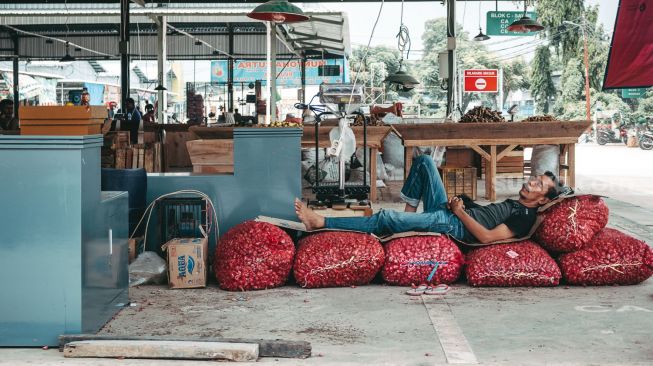 Seorang pedagang tengah beristirahat di Pasar Induk Jatiuwung, Tangerang. Senin 23 Agustus ( Suara.com/ Hilal Rauda Fiqry) 