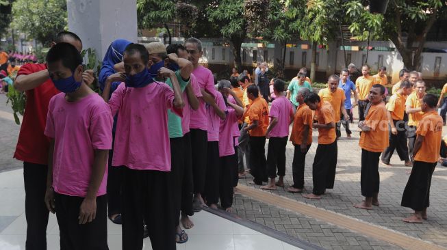 Sejumlah orang dengan gangguan jiwa (ODGJ) mengantre untuk menjalani tes usap (swab test) PCR di Panti Sosial Bina Insan Bangun Daya 2, Cipayung, Jakarta, Senin (23/8/2021). [Suara.com/Angga Budhiyanto]