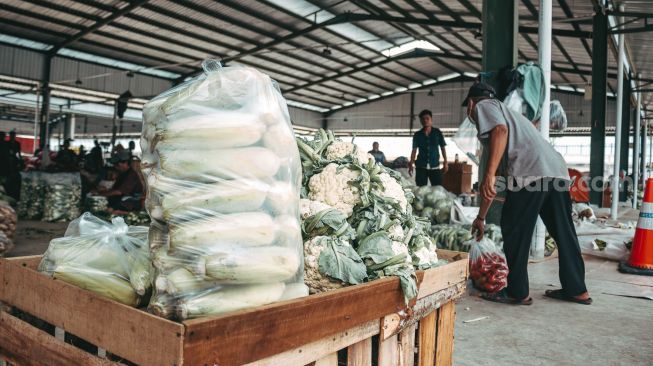 Pedagang merapikan cabai  sayur di Pasar Induk Jatiuwung, Tangerang, Senin (23/8). (Suara.com/ Hilal Rauda Fiqry)