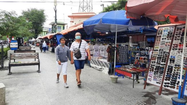 Wisatawan melintasi lapak Pedagang Kaki Lima (PKL) di sekitar Pasar Sore, Malioboro, Kota Jogja, Minggu (22/8/2021). - (SuaraJogja.id/Muhammad Ilham Baktora)