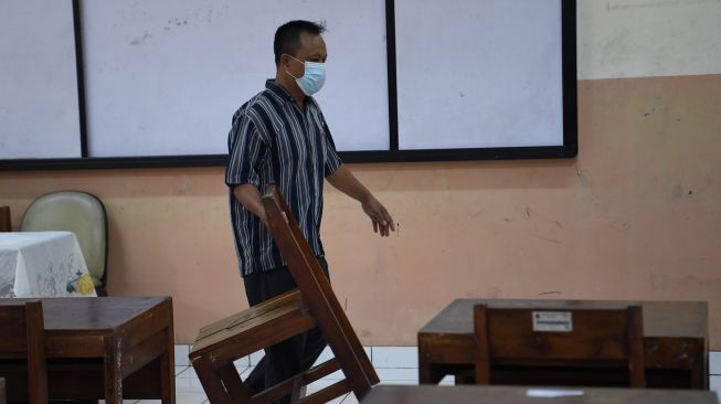 Pekerja menata bangku di ruang kelas sekolah di SMA Negeri 87, Jakarta, Selasa (24/8/2021). ANTARA FOTO/Hafidz Mubarak 