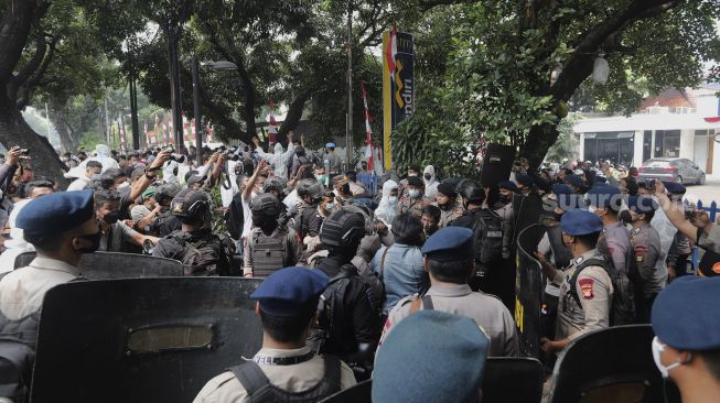 Petugas kepolisian membubarkan paksa pengungsi Afghanistan yang menggelar aksi unjuk rasa di depan Gedung UNHCR, Kebon Sirih, Jakarta, Selasa (24/8/2021). [Suara.com/Angga Budhiyanto]